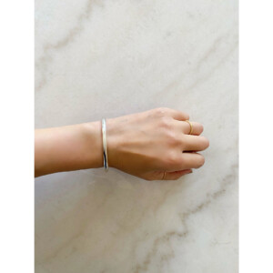 シルバー925のシンプルなCカフ、バングルを身につけた女性の手