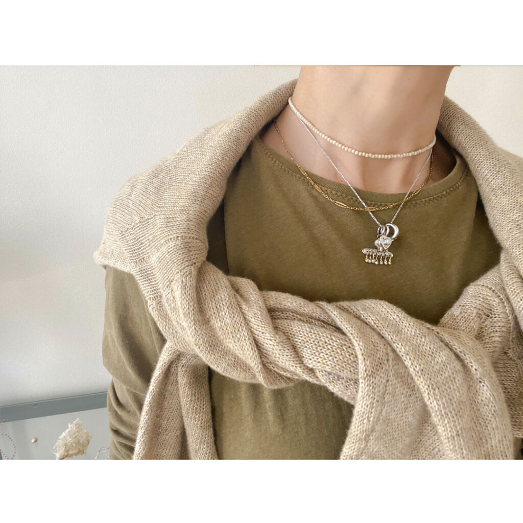 ヴィンテージチェーンのゴールドネックレスを身につけた女性