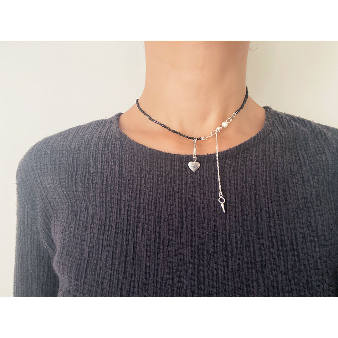 fig|ブラックスピネルのネックレスを身につけた女性