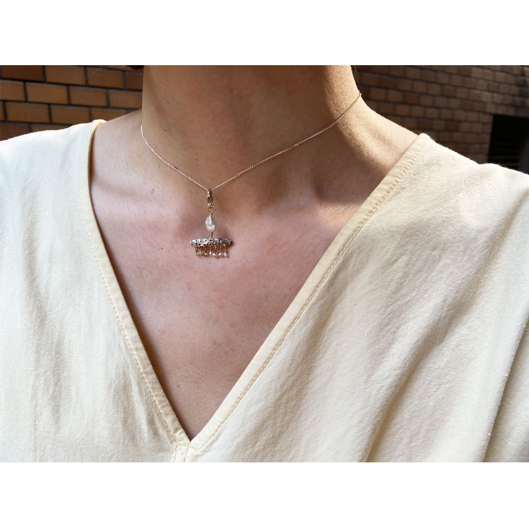 fig|パールとシルバーのネックレスを身につけた女性