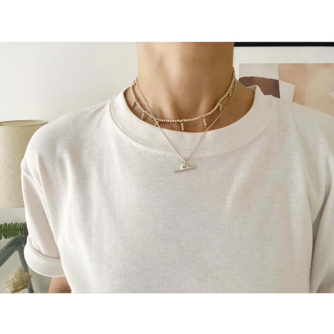 fig|シルバーのネックレスとリバーストーンを身につけた女性