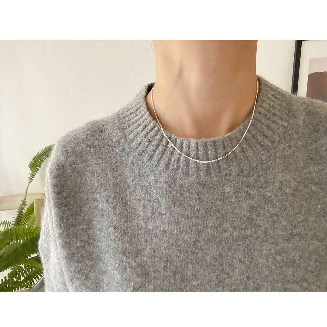 シルバーチェーンネックレスを身につけた女性