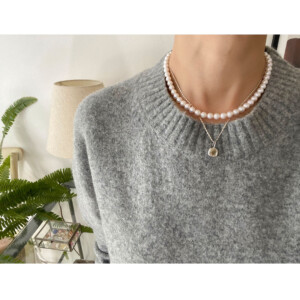 シルバーチェーンネックレスとパールネックレスを身につけた女性