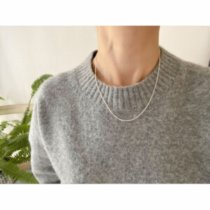 フリーアジャスターのシルバーチェーンネックレスを身につけた女性