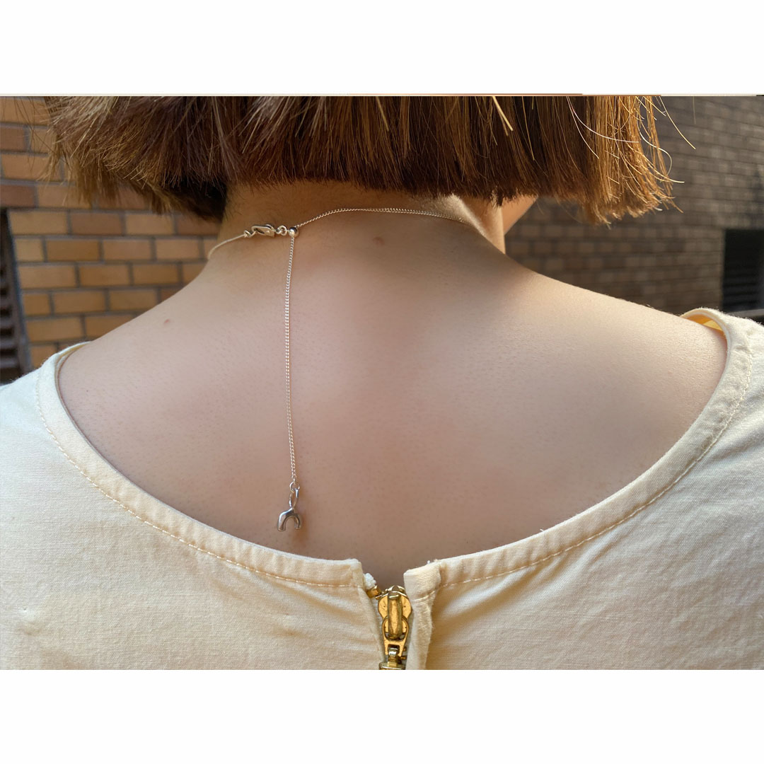 フリーアジャスターのシルバーチェーンネックレスを身につけた女性