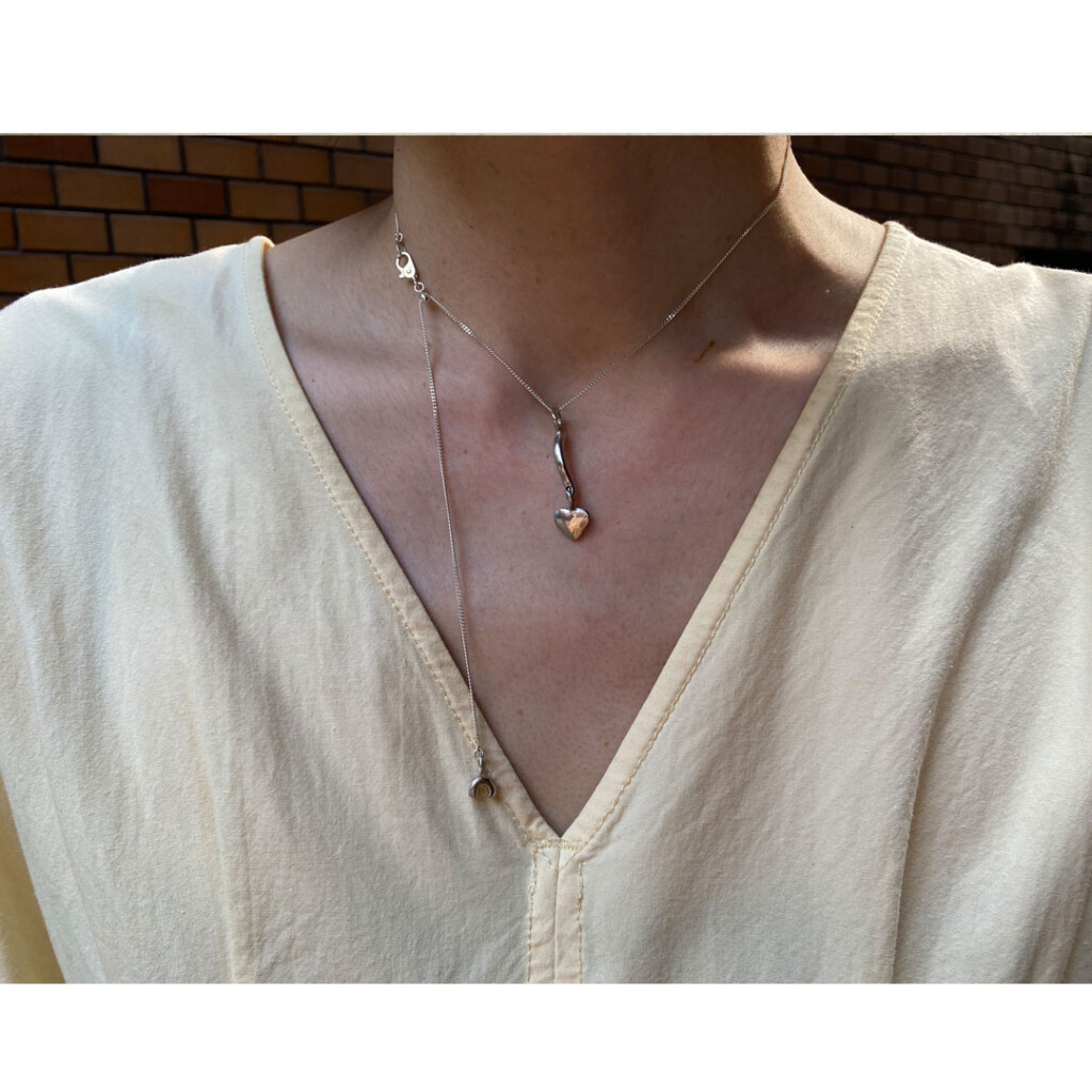 フリーアジャスターのシルバーチェーンネックレスを身につけた女性