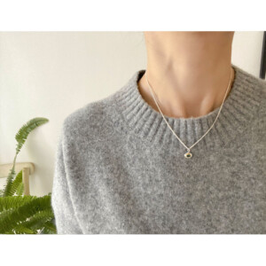 エメラルドのシルバーペンダントトップを身につけた女性