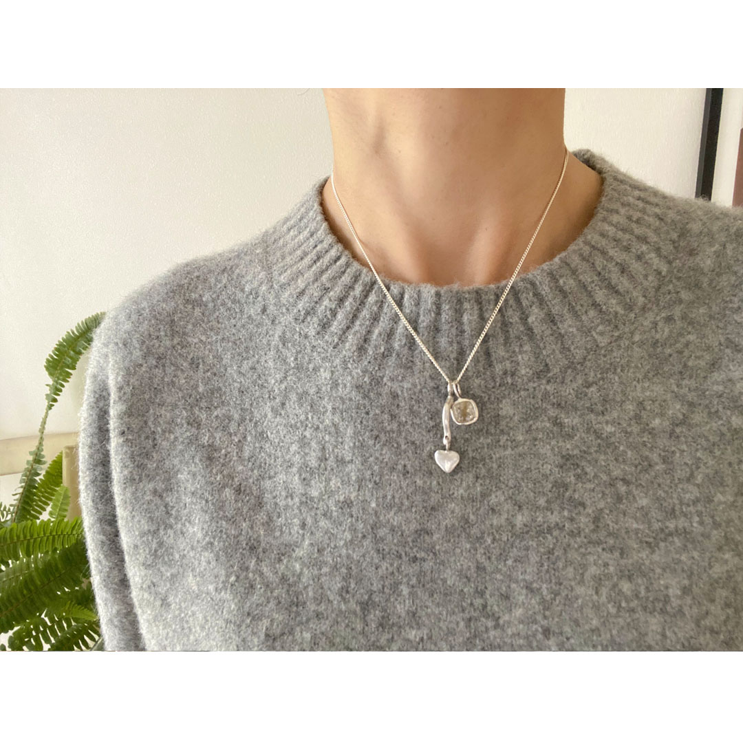 ルチルクオーツのペンダントトップを身につけた女性